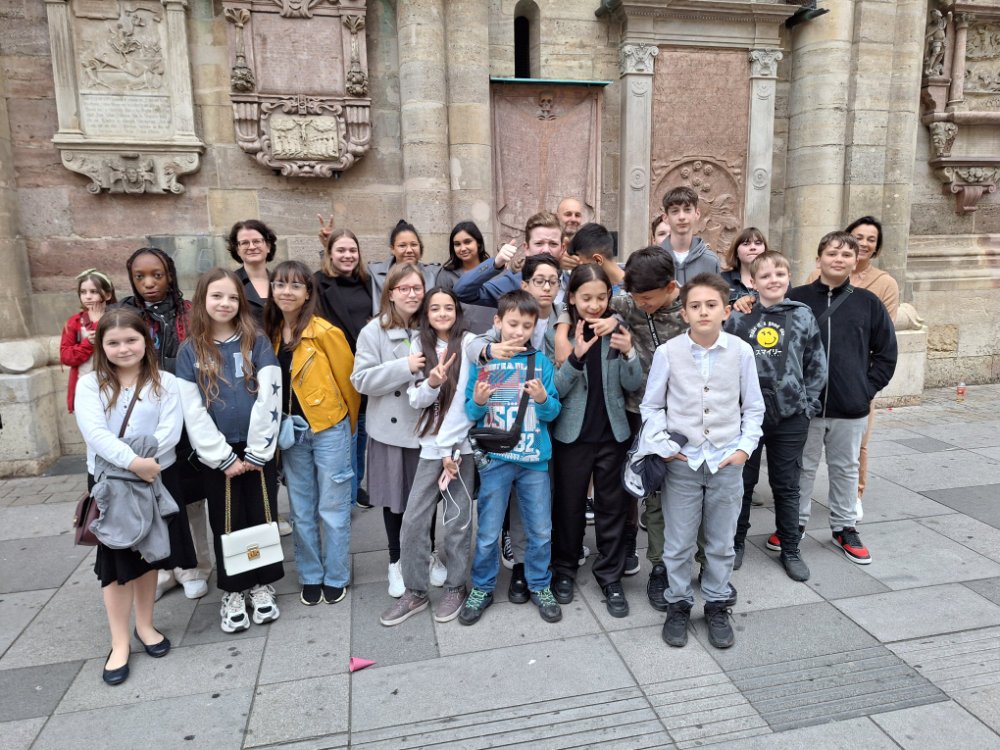 Eine Gruppe von Kindern posiert für ein Gruppenfotos vor dem Wiener Stephansdom.