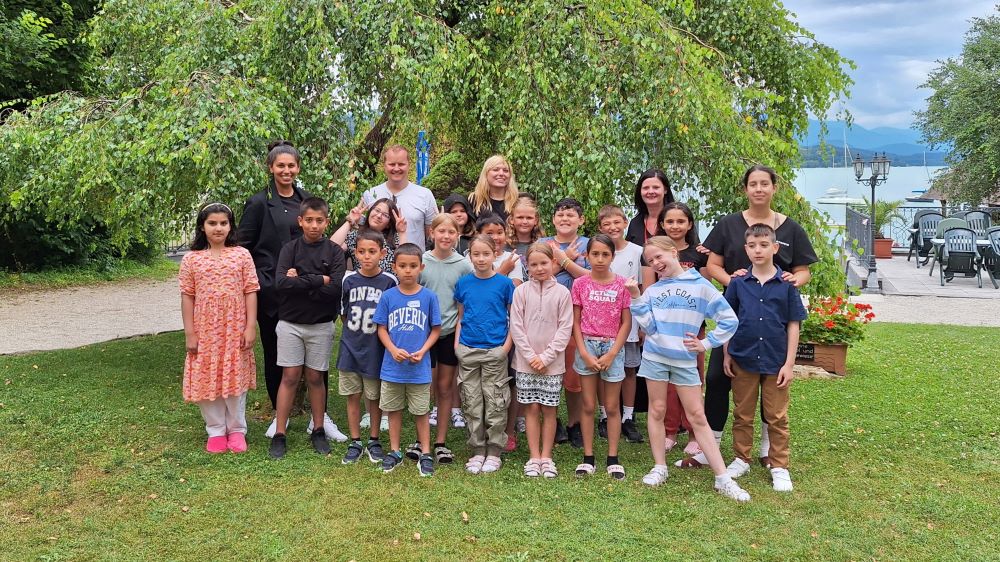 Kinder und Betreuer:innen posieren für ein Gruppenfoto.