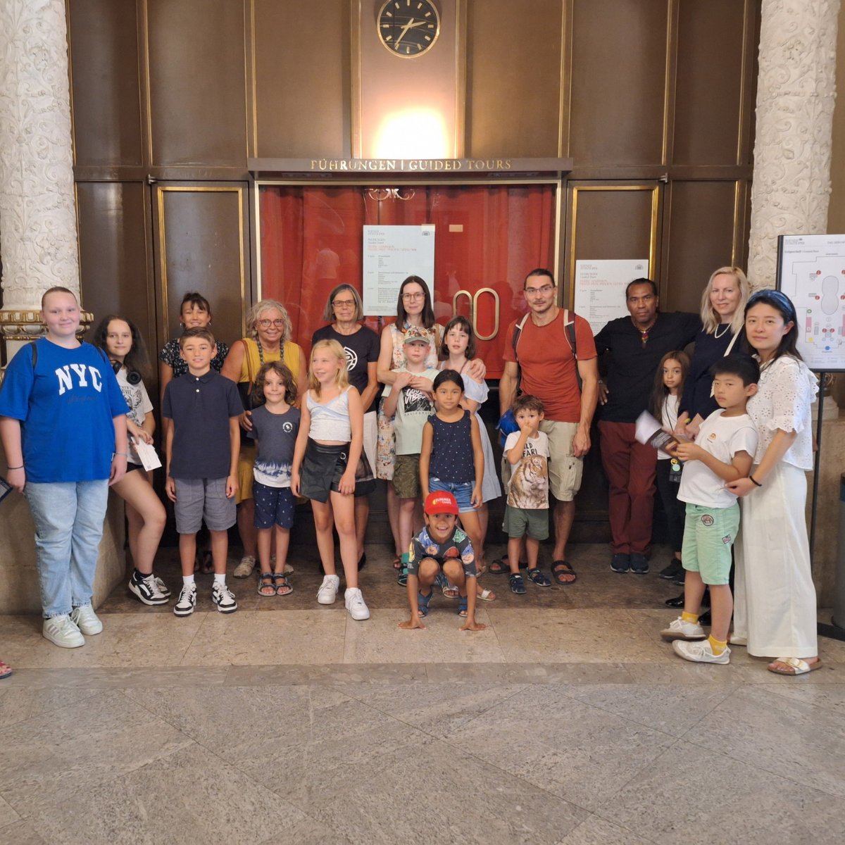 Familien und ihre Kinder posieren für ein Gruppenfoto in der Staatsoper Wien.