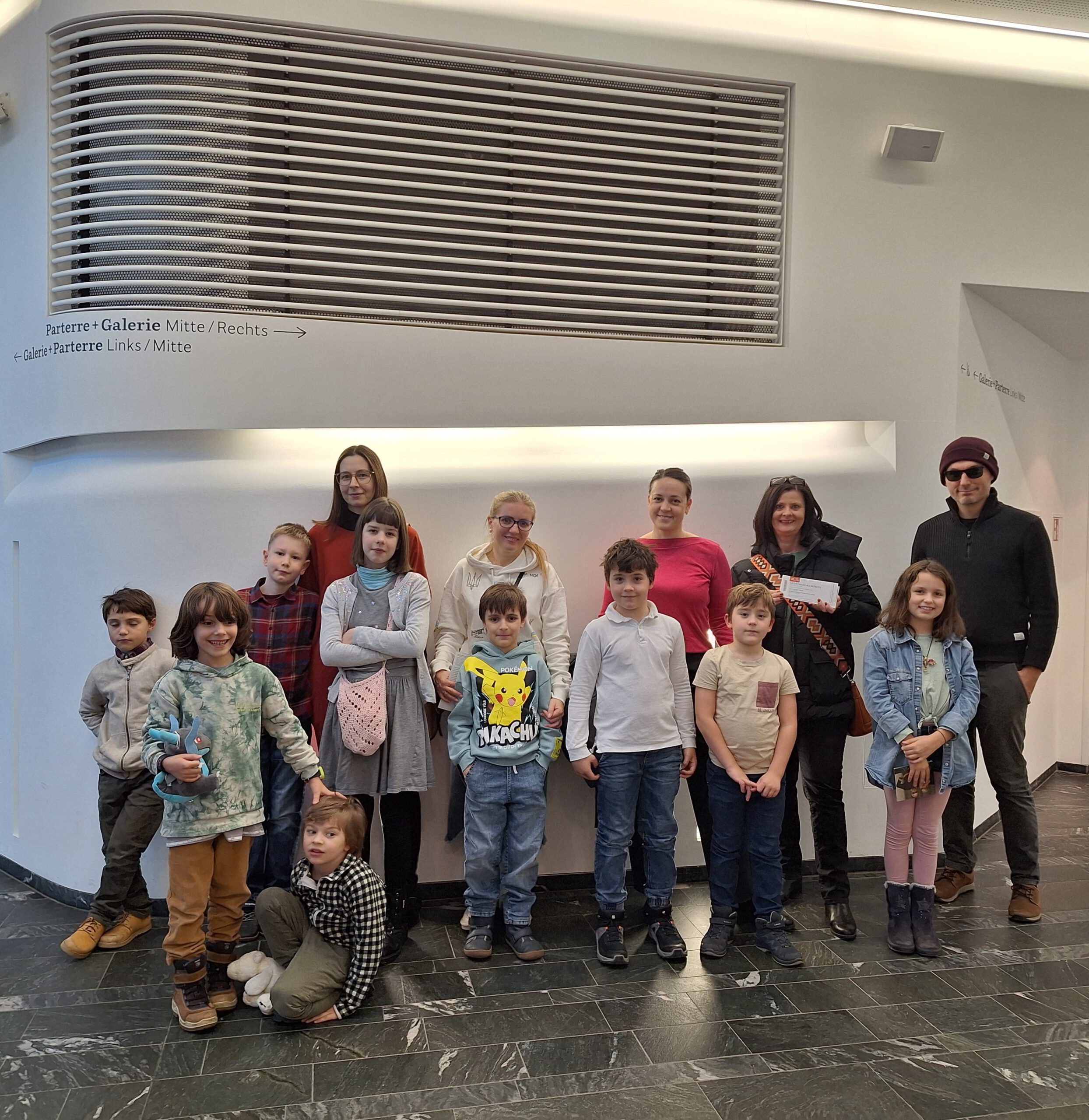 Kinder und Familien posieren für ein Gruppenfoto.