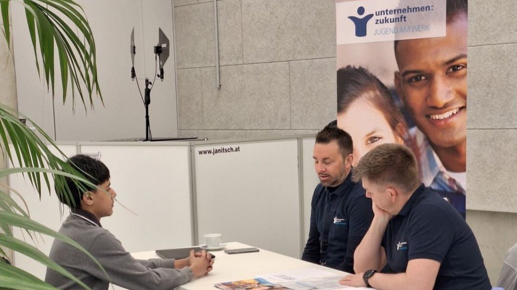 Zwei Mitarbeiter von Jugend am Werk und ein Jugendlicher sitzen gegenüber an einem
Tisch und führen ein Bewerbungsgespräch.