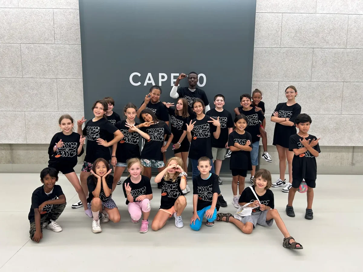 Ein Gruppe von Jugendlichen und Kindern posiert im CAPE 10 Veranstaltungsraum.
