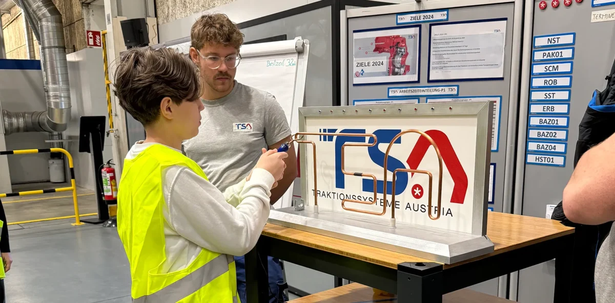 Ein Jugendlicher absolviert unter der Aufsicht eines Mitarbeiters von TSA Austria eine Station bei einer Betriebsführung.