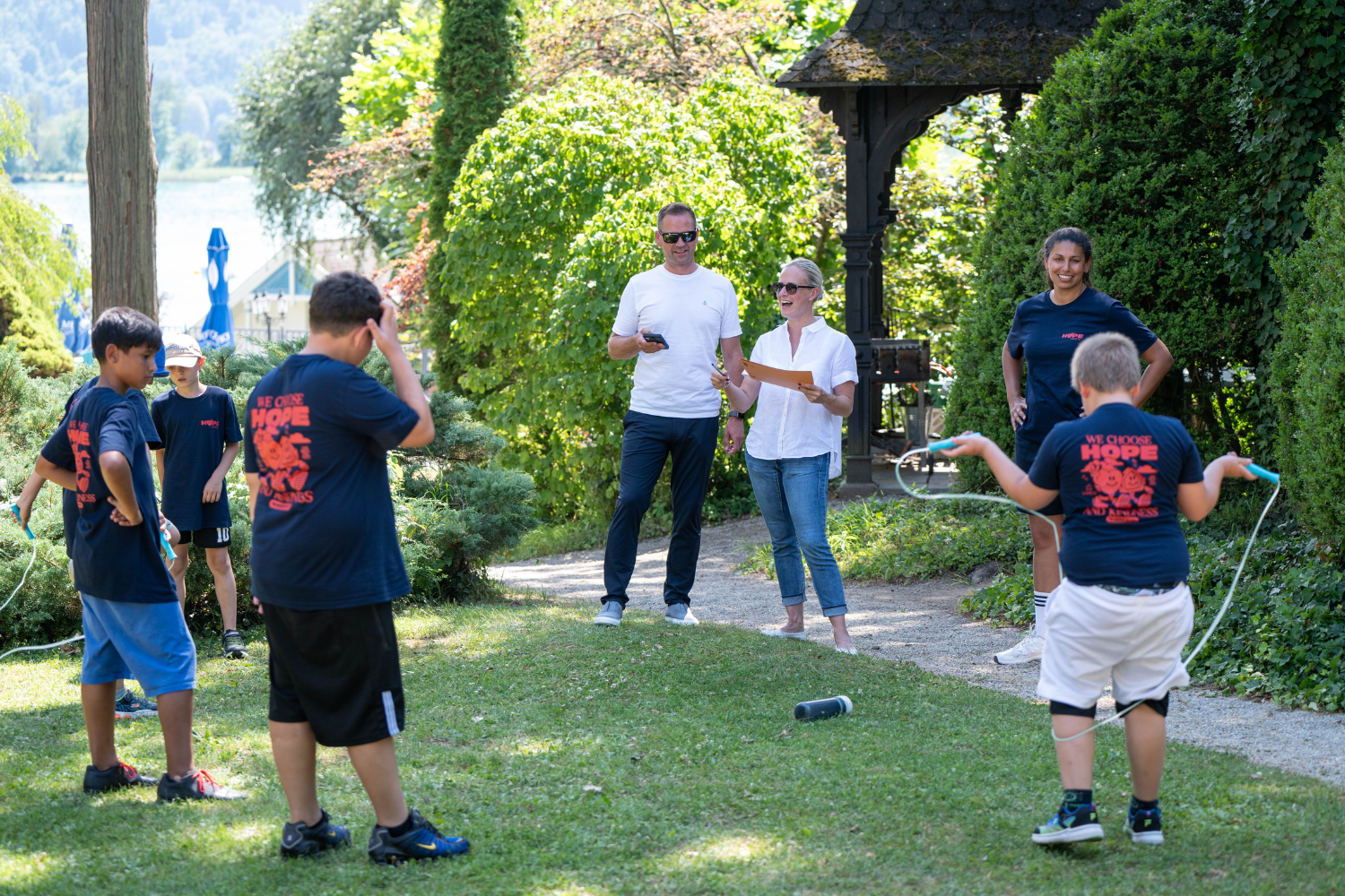 Ein Gruppe von Kinder springt Seil und Plasser & Theurer betreut die Station.