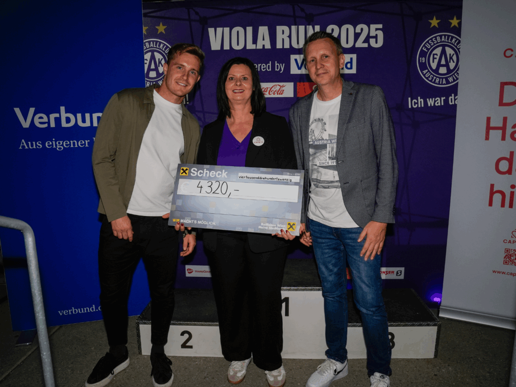 Elfriede Wittberger posiert mit Vertreter:innen des FK Austria Wien und einem Spendenscheck.