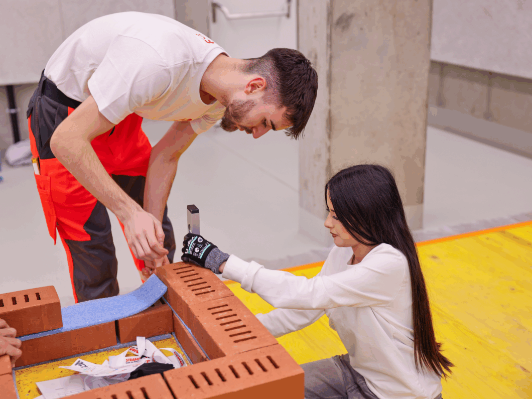 STRABAG-Lehrling und Mittelschülerin beim Bau eines Schachtes.