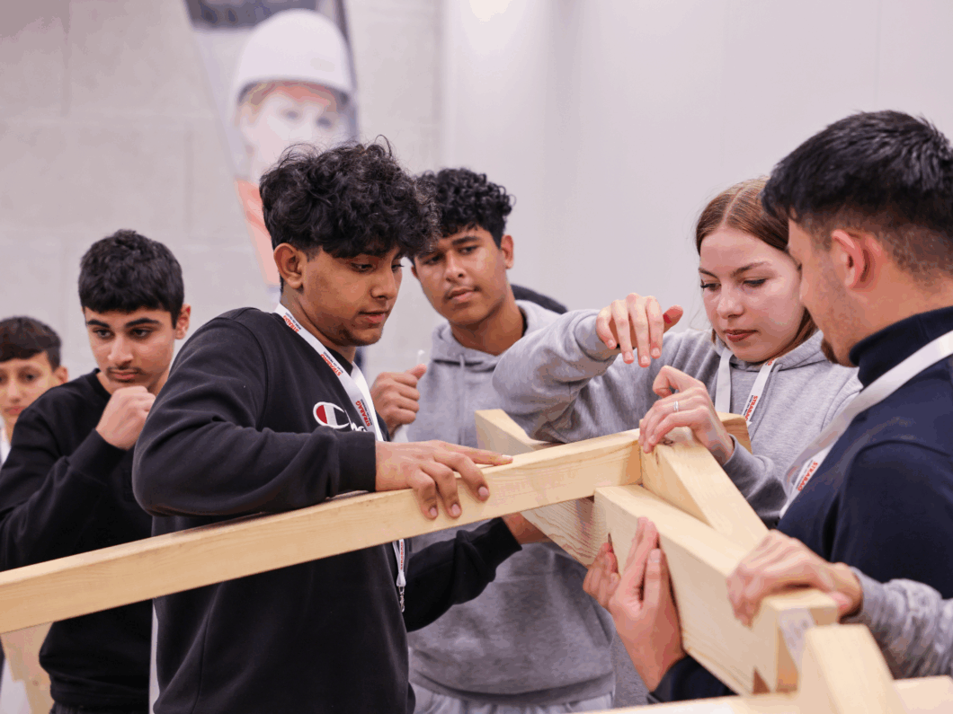 Kinder bauen gemeinsam eine Da-Vinci-Brücke.