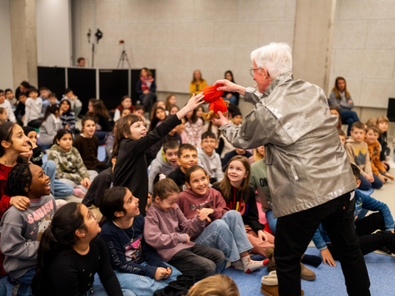 Albert Landertinger geht mit einem Alien Stofftier durch die Zuschauerreihen.