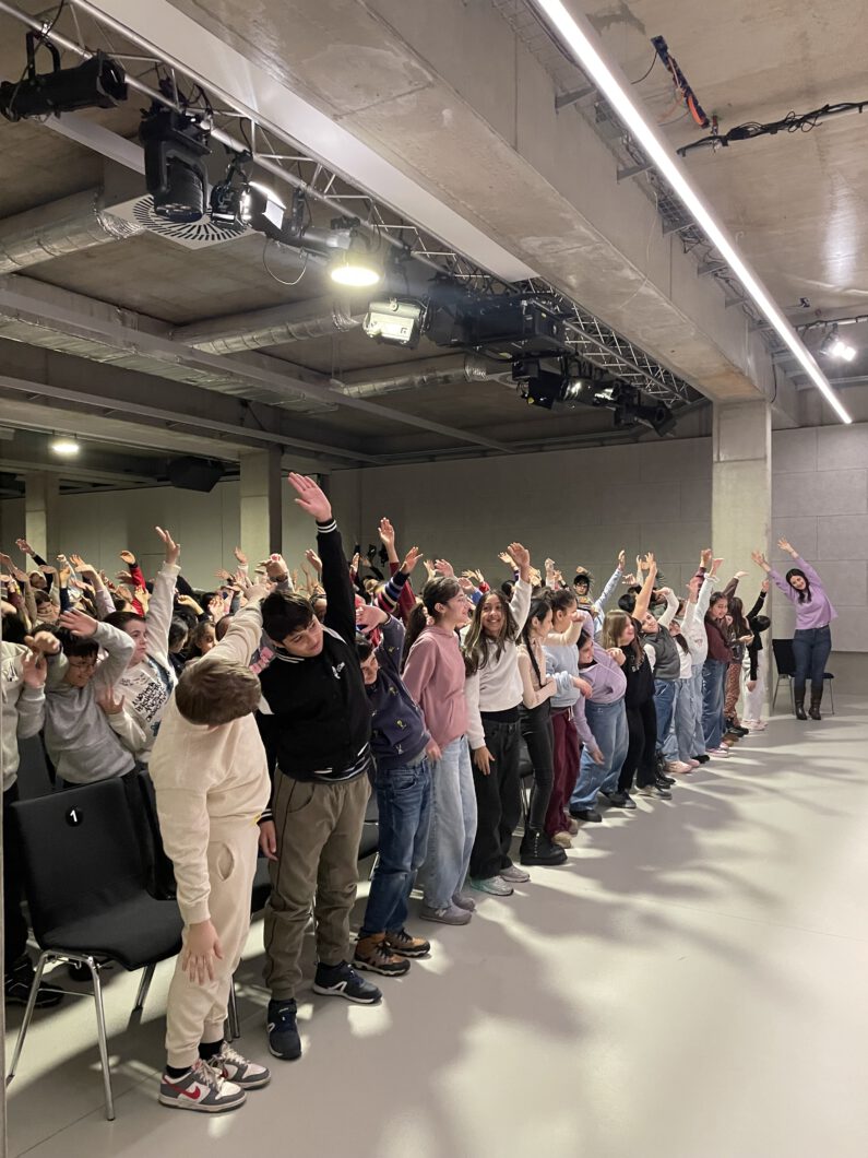 Einige Kinder strecken die Hände in die Luft und lachen dabei,