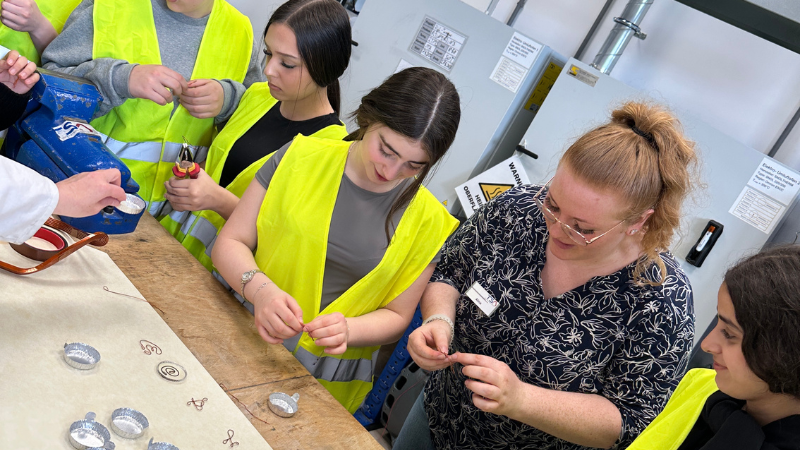 Mädchen biegen gemeinsam mit einer Mitarbeiterin von TSA Drähte beim Girls Day 2025.