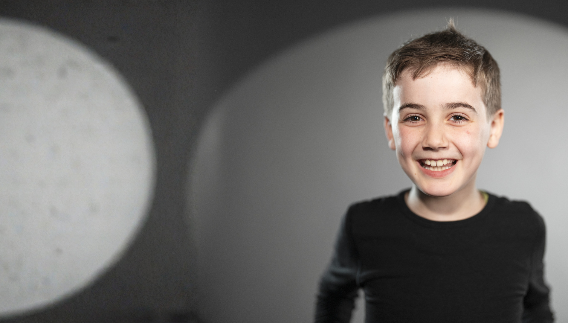 Bub blickt lachend in die Kamera.