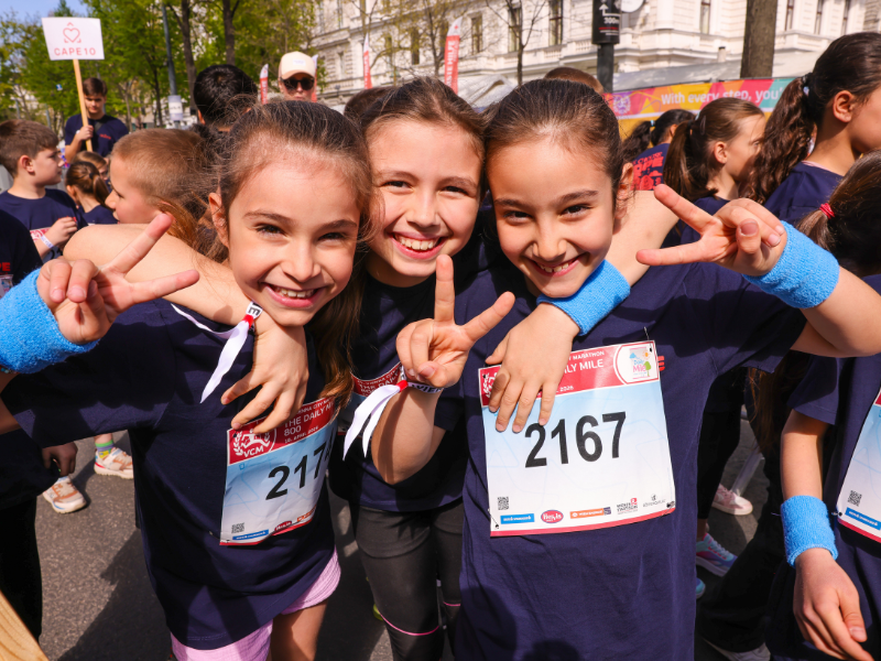 Drei Mädchen posieren lächelnd und umarmen sich.