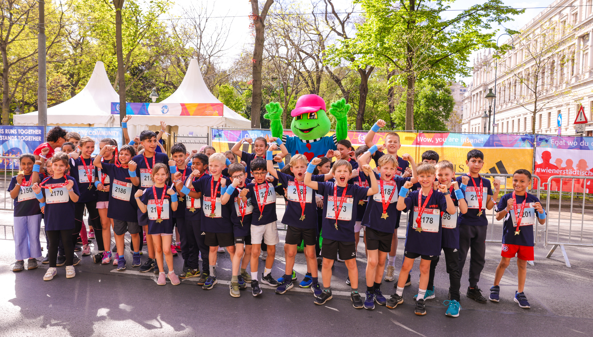Kinder posieren beim VCM Lauf mit Hopsi Hopper.